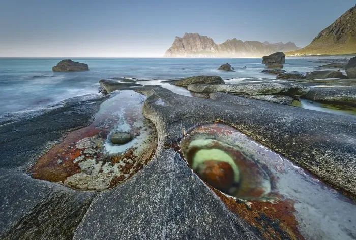 Framed Print : Rocks on the beach, in front tidal pond with formation Eye of Utakleiv