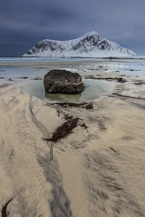 Framed Print : Rocks lying on the beach in front of snowy mountains Framed Print : Rocks lying on the beach in front of snowy mountains