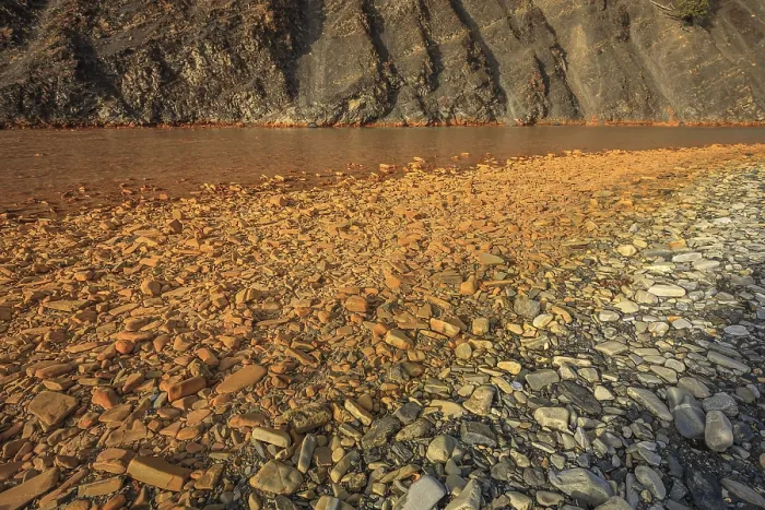 Framed Print : Rocks along the riverbank are stained by dissolved iron and other minerals in the water