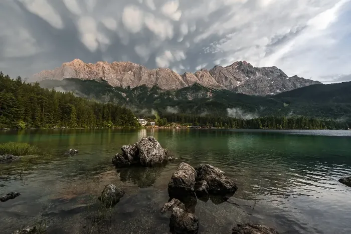 Framed Print : Rocks on the shore, Eibsee lake in front of Zugspitze massif with Zugspitze