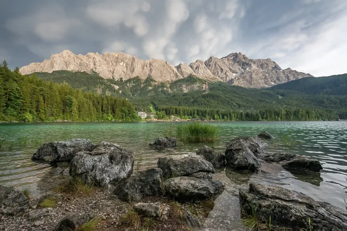 Framed Print : Rocks on the shore, Lake Eibsee lake in front of Zugspitze massif with Zugspitze