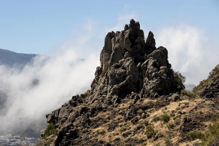 Framed Print : Rocky peak surrounded by clouds