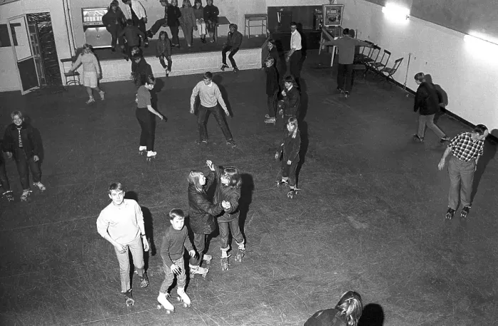 Framed Print : Roller skate fun in the 1960s. Interior of a roller disco with people roller skating. Roller skating began to trend at this time and throughout the 1970s when roller skating was associated with disco music and roller discos
