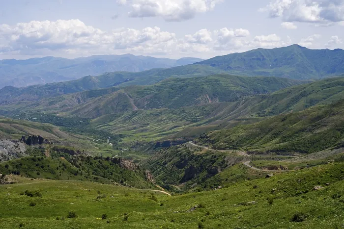 Framed Print : Rolling hills and mountains around a wide valley with green vegetation