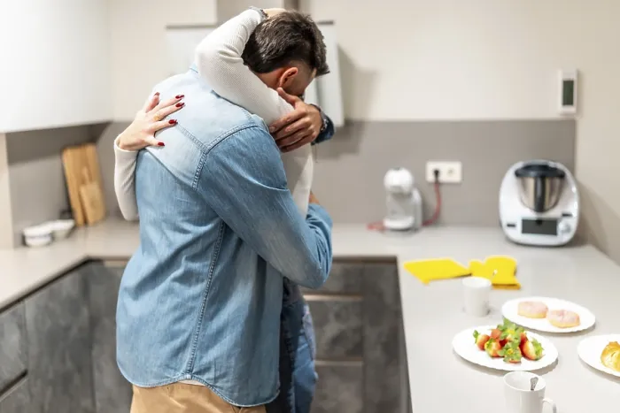 Framed Print : Romantic couple embracing in a cozy kitchen