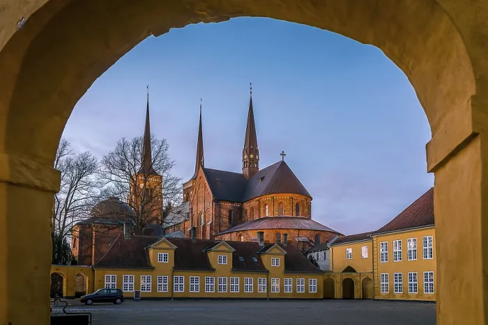 Framed Print : Roskilde cathedral in the soft sunset under the yellow portal of Roskilde Palace