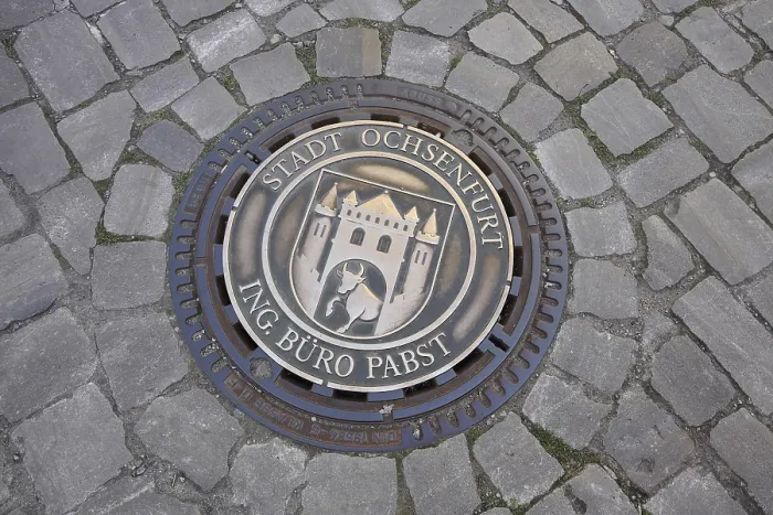 Framed Print : Round manhole cover with town coat of arms and inscription Framed Print : Round manhole cover with town coat of arms and inscription