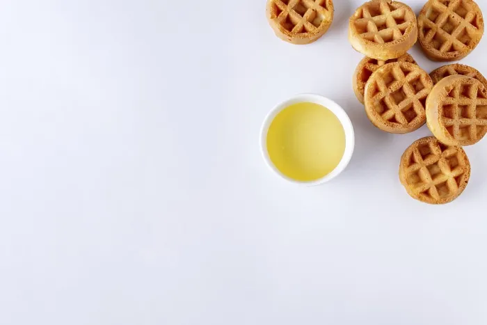 Framed Print : Round small waffles and a cup with honey on a white background Framed Print : Round small waffles and a cup with honey on a white background
