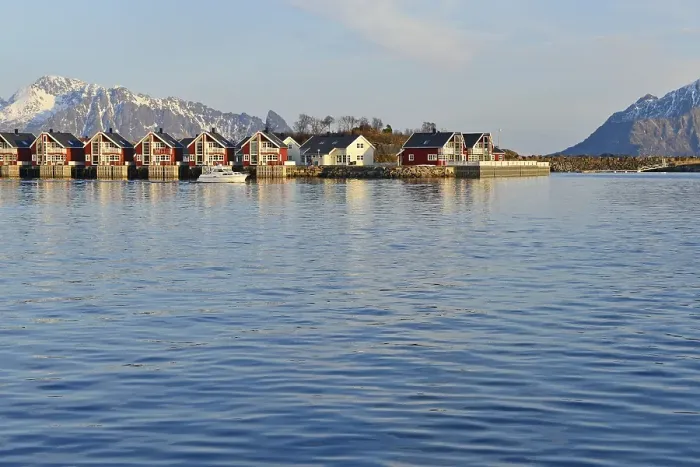 Framed Print : Row of red cottages by the blue water