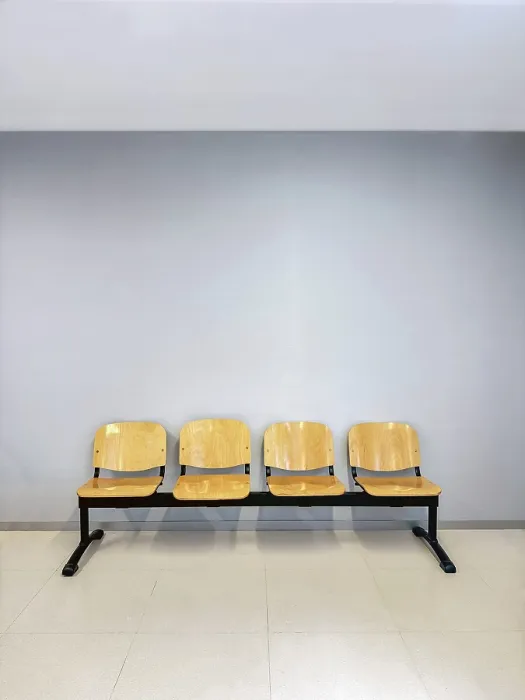 Framed Print : A row of four wooden chairs with metal frames placed against a light gray wall Framed Print : A row of four wooden chairs with metal frames placed against a light gray wall