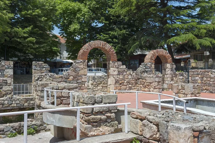 Framed Print : Ruins of an ancient structure with brick arches in an urban setting under a blue sky