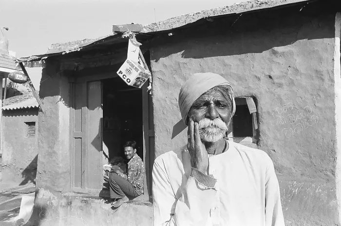 Framed Print : Rural man standing outside of his house