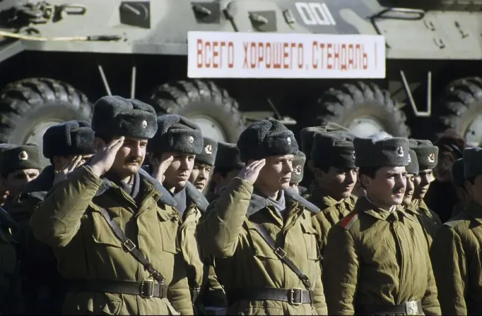 Framed Print : Russian soldiers saluting in front of a train transporting armoured vehicles during the withdrawal of Soviet troops