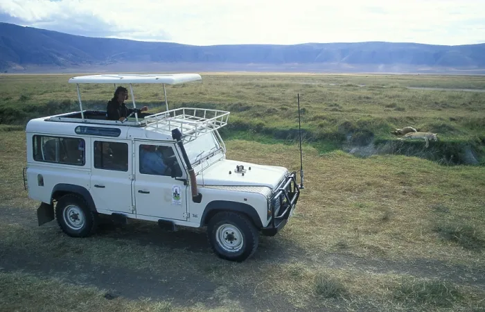 Framed Print : Safari, tourists watch a lioness resting next to her prey from a safari vehicle in the Ngorongoro Crater