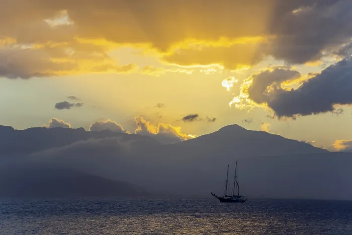 Framed Print : A sailboat on the sea in front of a dramatic sunset