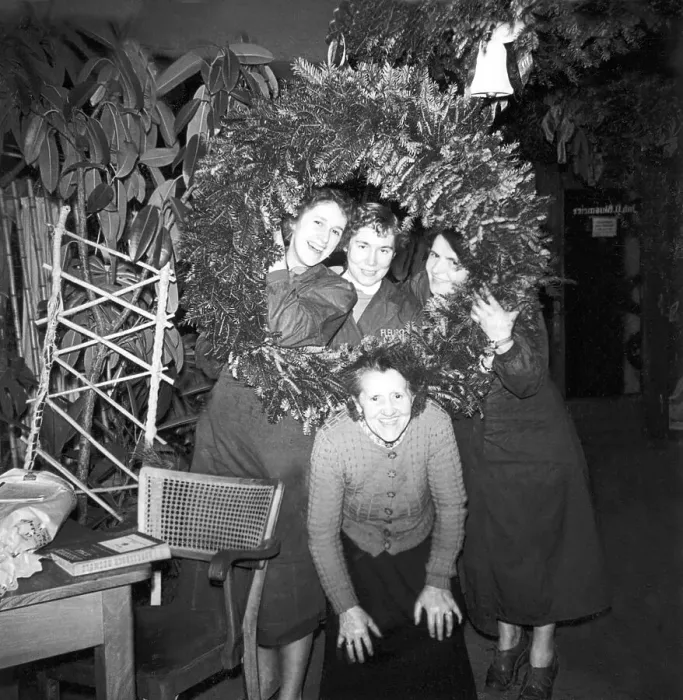 Framed Print : Saleswomen of a flower shop posing in front of a large Advent wreath