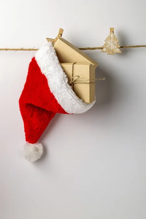 Framed Print : Santa Claus hat with gifts hanging on a rope on a white background