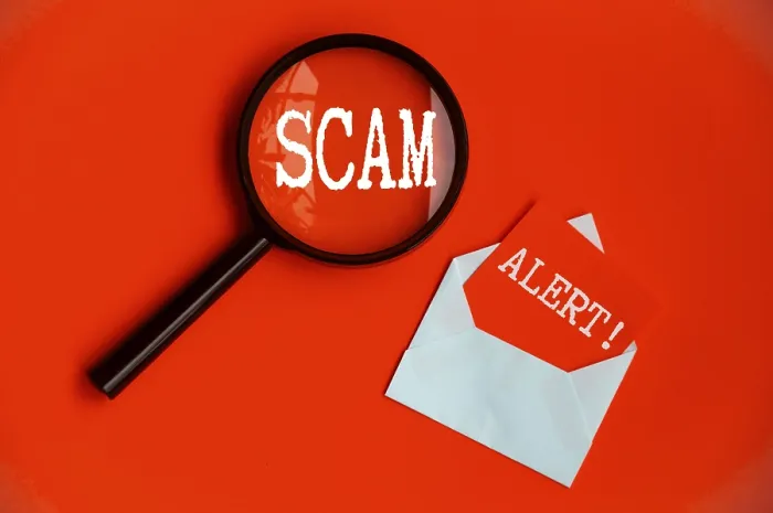 Framed Print : Scam Alert text on magnifying glass and notepad on red cover background