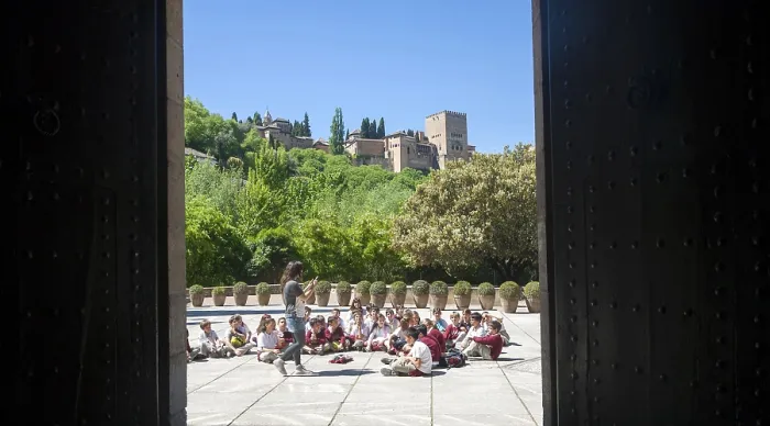 Framed Print : School children listen to their teacher on an educational visit to the historic sites of Granada