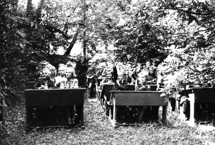 Framed Print : School class sits on wooden benches in the open air Framed Print : School class sits on wooden benches in the open air