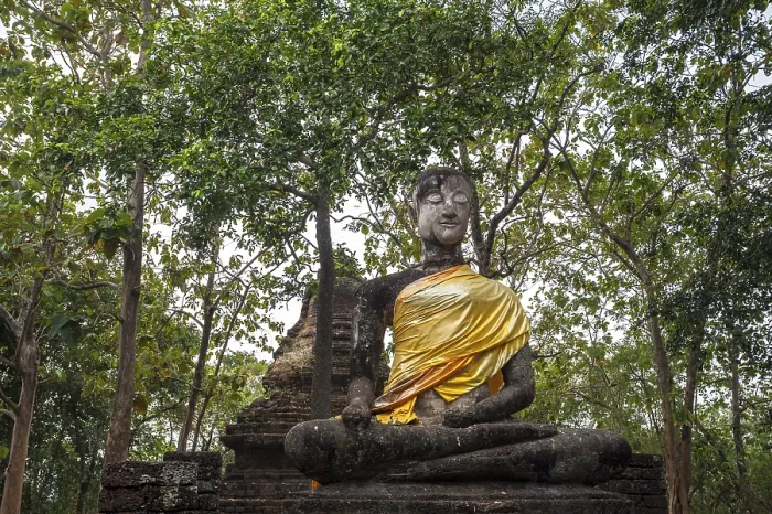 Framed Print : Seated Buddha statue in front of a chedi