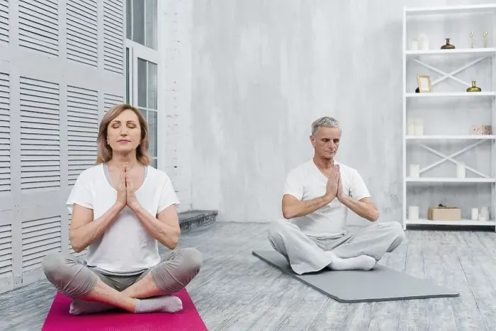Framed Print : Senior couple meditating with praying hands yoga mat home Framed Print : Senior couple meditating with praying hands yoga mat home