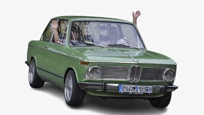 Framed Print : Senior couple waving from vintage green BMW during a summer road trip