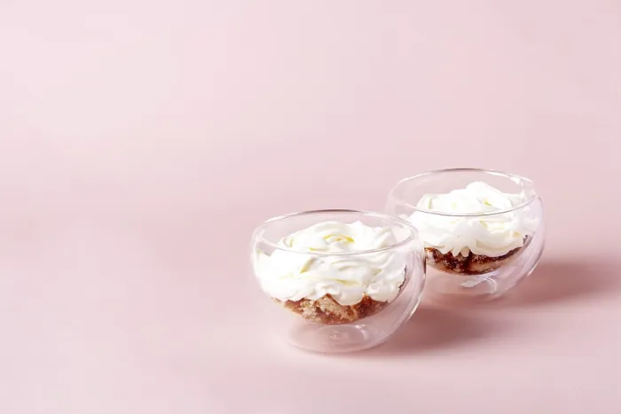 Framed Print : Two servings of tiramisu in a glass cup on a beige background Framed Print : Two servings of tiramisu in a glass cup on a beige background
