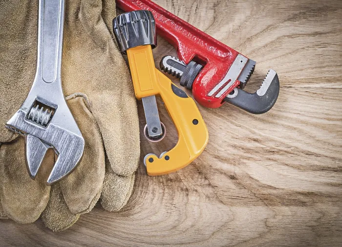 Framed Print : Set of protective gloves adjustable spanner monkey wrench pipe cutter on wooden board plumbing concept