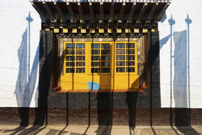 Framed Print : Shadows of prayer flags against the colorful windows and wall of the Pemayagtse buddhist monastery in Pelling