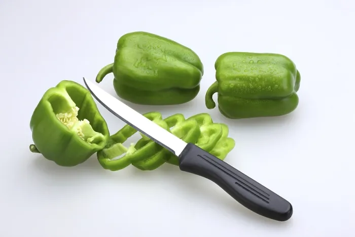 Framed Print : Sharp knife with black handle with slices of Green Capsicums Latin Capsicum Annuum