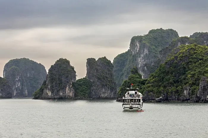 Framed Print : Ship sails in foggy waters surrounded by lush rock formations