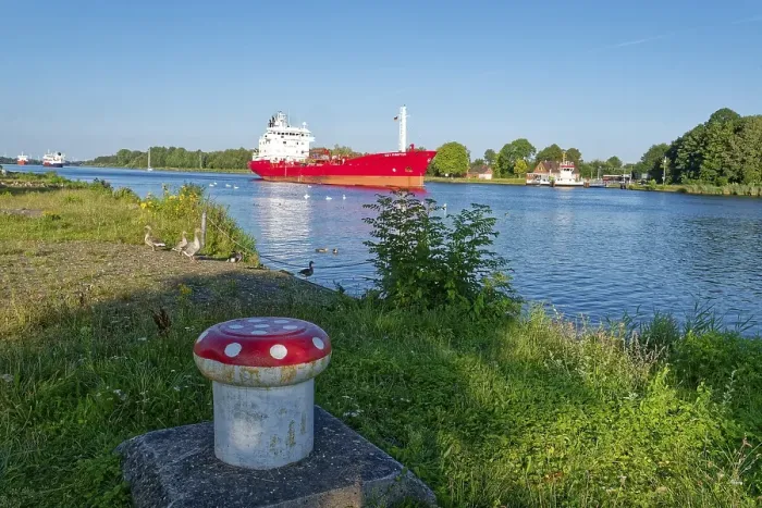 Framed Print : Shipping traffic heading north in the evening on the Kiel Canal and wild geese on the shore