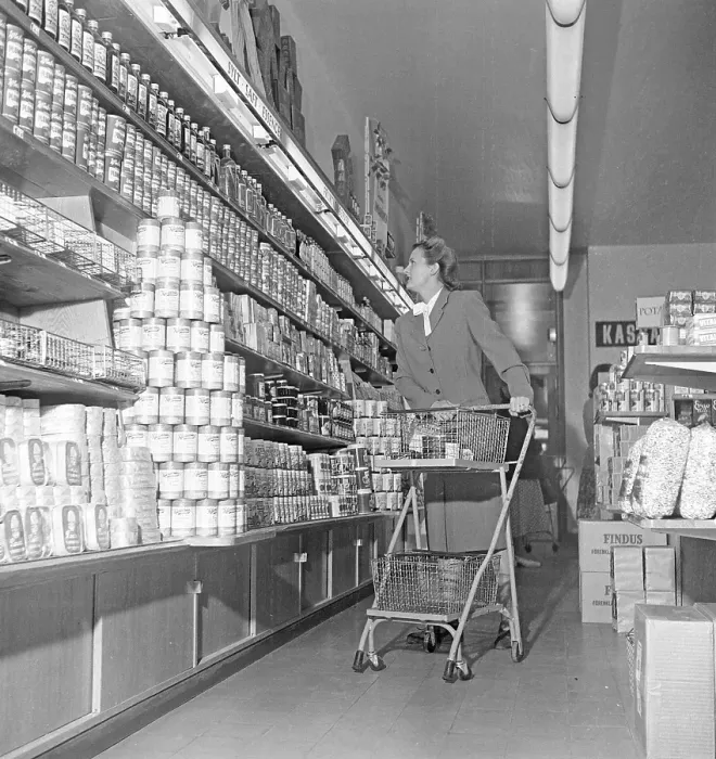 Framed Print : Shopping in the 1940s. A woman shops in a self service store