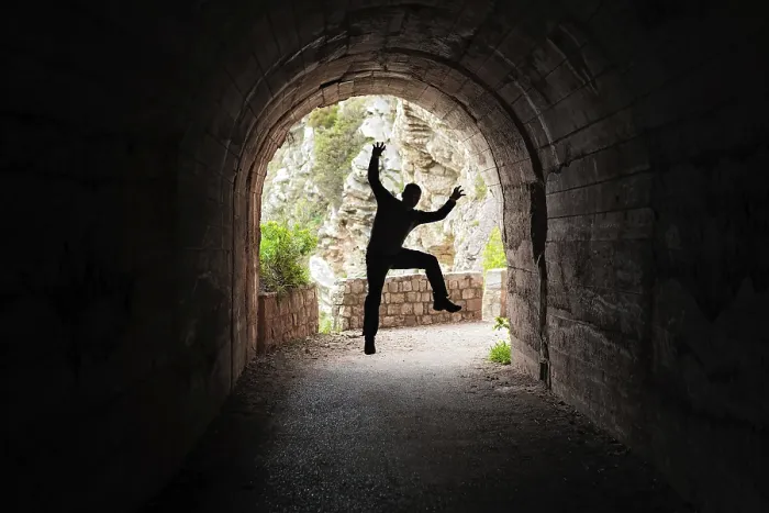 Framed Print : Silhouette of a man jumping in a dark tunnel on the walking path in Petrovac bay Framed Print : Silhouette of a man jumping in a dark tunnel on the walking path in Petrovac bay