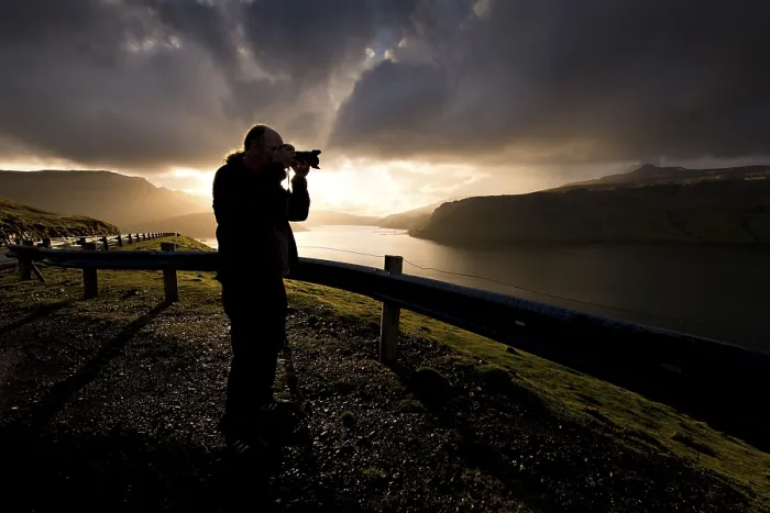 Framed Print : Silhouette of a photographer standing in front of dramatic