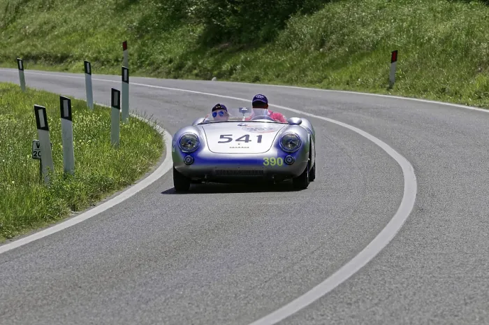 Framed Print : A silver racing car with two people drives swiftly along a winding road