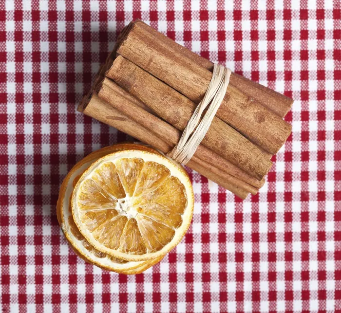 Framed Print : Slices of dried orange and cinnamon sticks on a chequered cloth