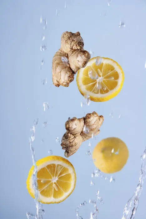 Framed Print : Slices of lemon, ginger in splashes of water fly on a blue background