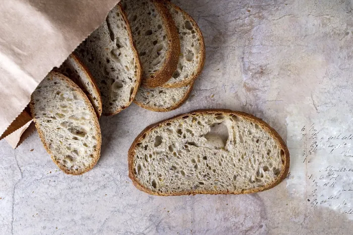 Framed Print : Slices of yeast-free bread with cereal poured out of a paper bag on a beige background Framed Print : Slices of yeast-free bread with cereal poured out of a paper bag on a beige background