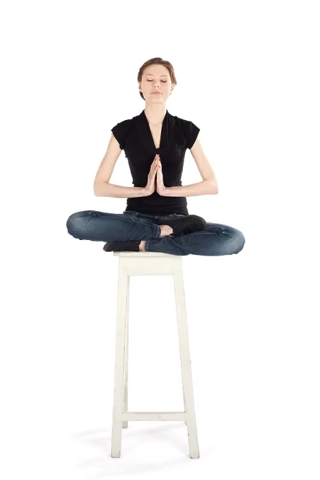 Framed Print : Slim woman sitting on high stool doing yoga meditation technique isolated on white background