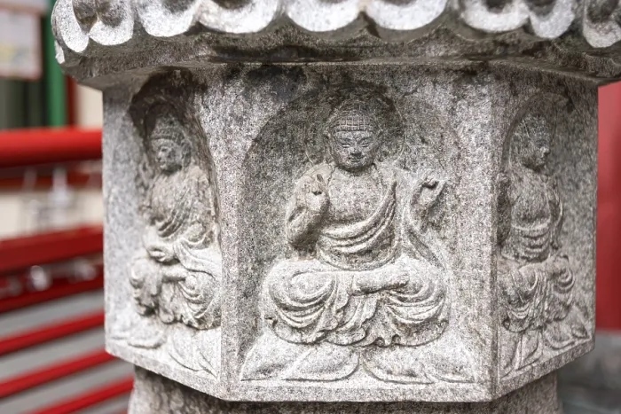 Framed Print : Small Buddha relief on stone lantern pedestal near the temple