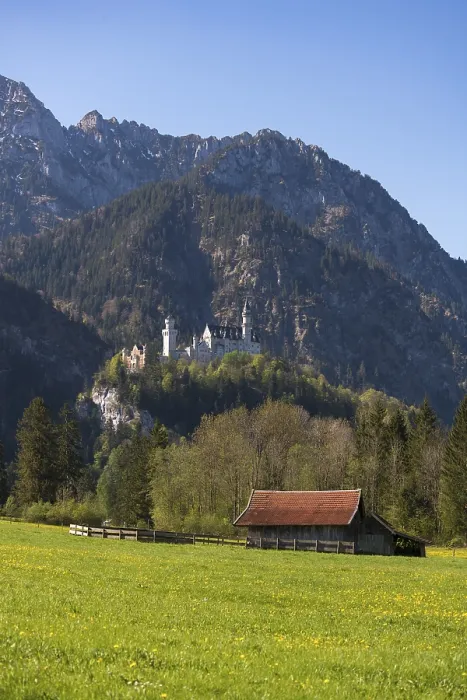 Framed Print : A small hut on a wide meadow with a castle majestically perched on a mountain peak behind it Framed Print : A small hut on a wide meadow with a castle majestically perched on a mountain peak behind it