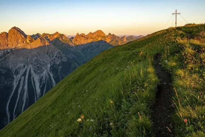 Framed Print : Small mountain trail with flower meadow and summit of the Uentschenspitze at sunrise
