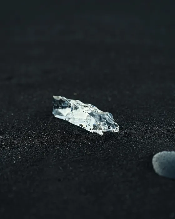 Framed Print : Small piece of ice isolated on black sand