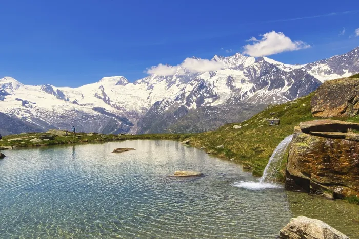 Framed Print : Small waterfall flows into a clear mountain lake against a mountain backdrop