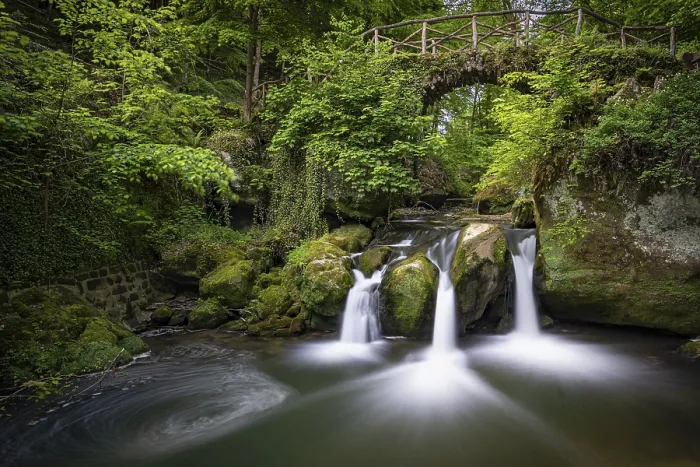 Framed Print : Three small waterfalls under a wooden bridge