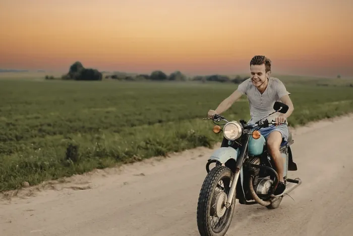 Framed Print : A smiling man rides a motorcycle down a rural road at sunset