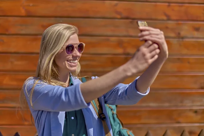 Framed Print : Smiling woman taking selfie in front of wooden wall during weekend trip adventure she shares online with her friends Framed Print : Smiling woman taking selfie in front of wooden wall during weekend trip adventure she shares online with her friends