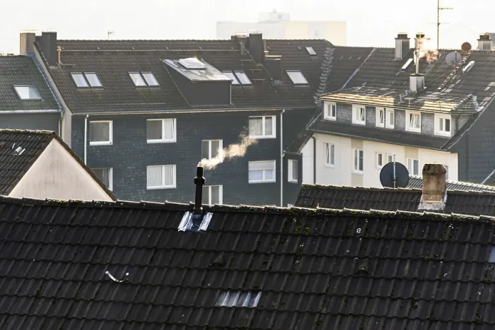 Framed Print : Smoke plume from a chimney over densely built residential area in the evening light